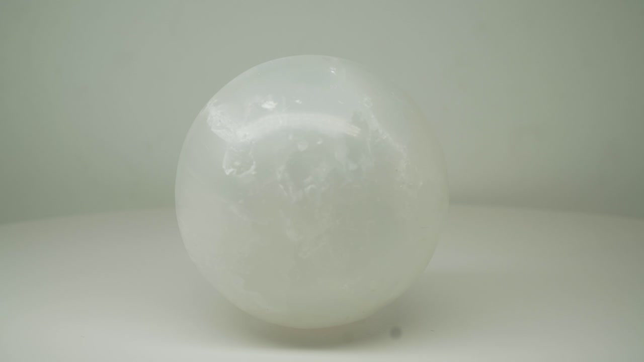 белый кристалл круглый l магический шар, вращающийся по часовой стрелке на чистом белом фоне - снимок крупным планом