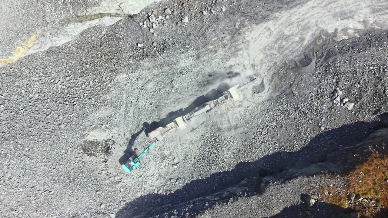 Granite quarry seen from above showing workers and machinery operating on rocky surface