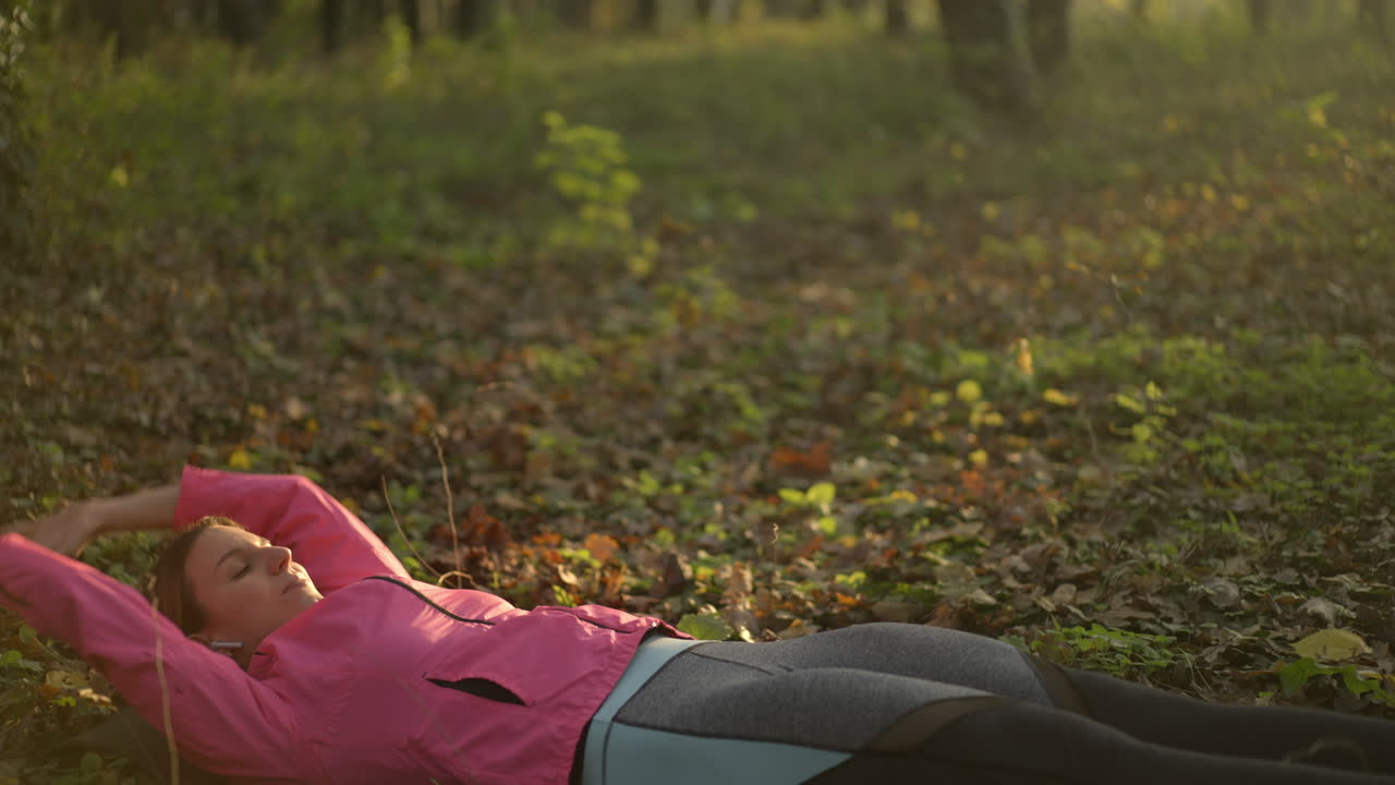 Donna che si allena e si rilassa in un bosco autunnale
