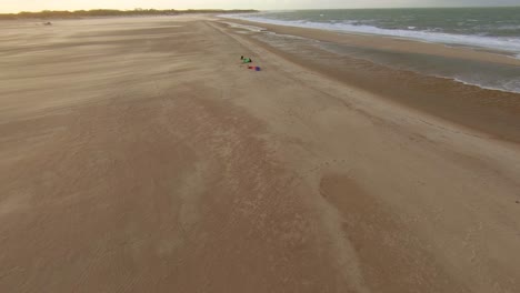 kitesurfistas instalando su equipo en una playa vacía en los países bajos