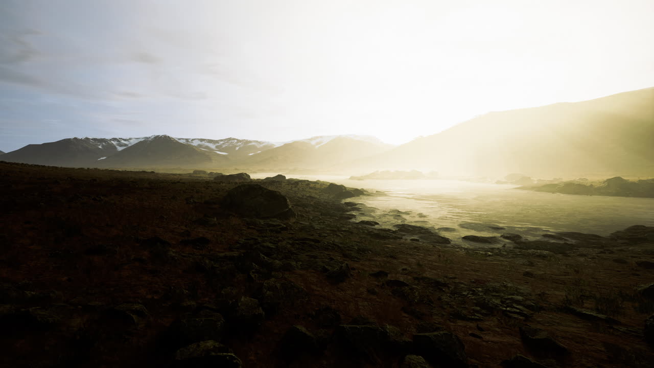 Stunning sunrise over misty mountains and calm waters