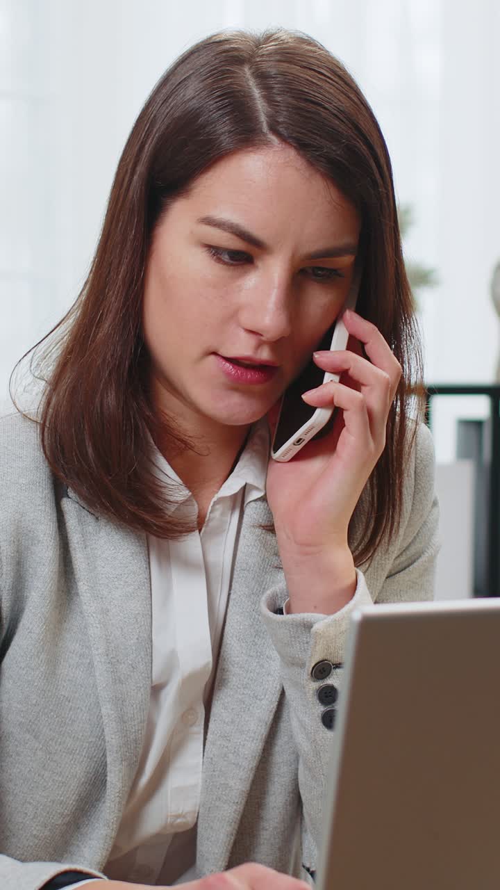 operadora de negocios que se comunica con el cliente a través de un teléfono inteligente haciendo notas en documentos en papel