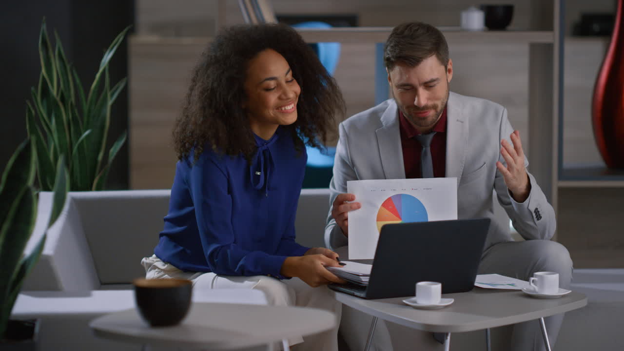 Multiethnic business team video calling using laptop computer in office cafe.