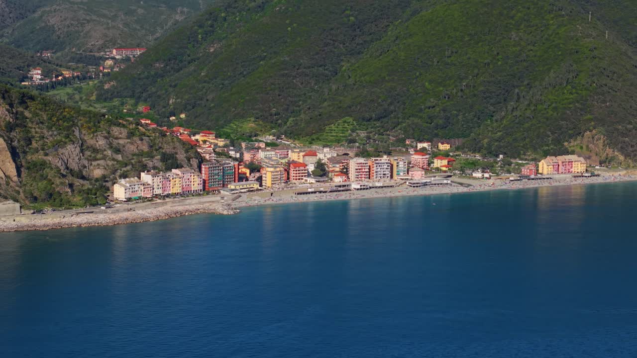 Veduta costiera di una città colorata in Italia sul mare in una giornata di sole, ripresa aerea.