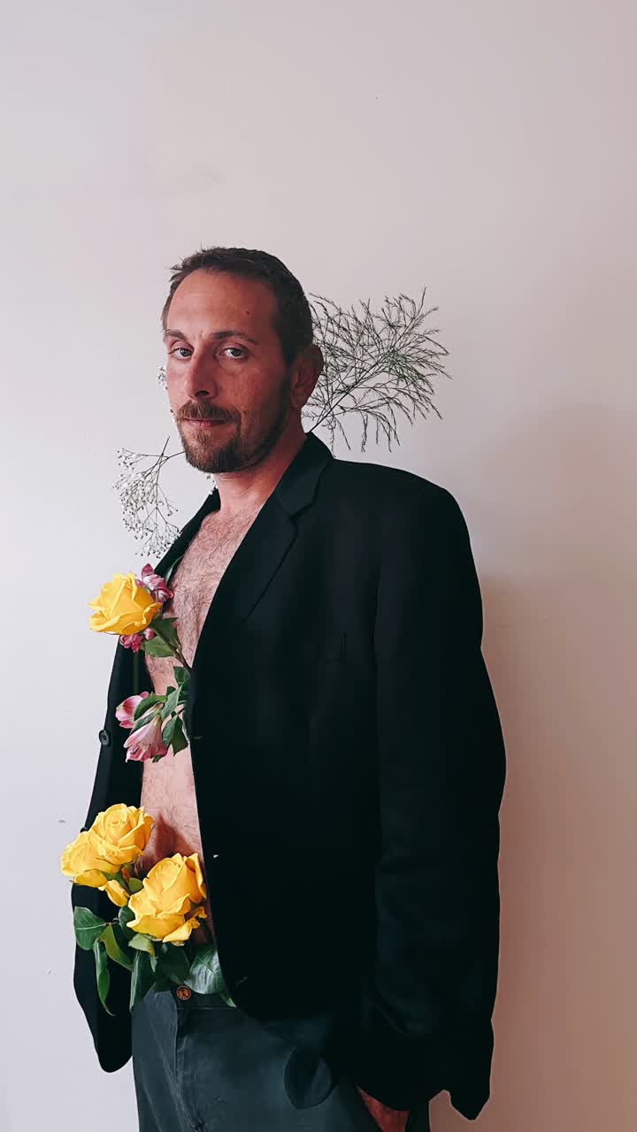 hombre en traje negro con flores