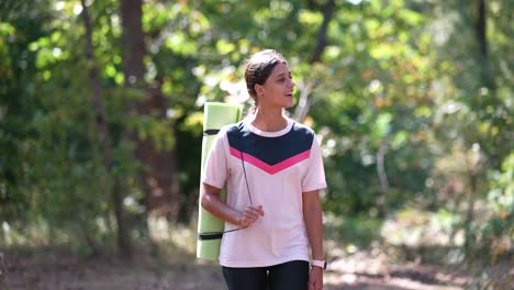 young woman exercising in nature with yoga mat
