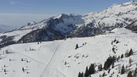 Emoción-De-Los-Deportes-De-Invierno,-Pistas-De-Esquí-Cubiertas-De-Nieve-En-Folgarida,-Dolomitas-Aéreas-Panorámicas