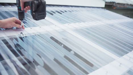 Screwing-The-Corrugated-Polycarbonate-Roof-Sheets-Of-Greenhouse-Garden