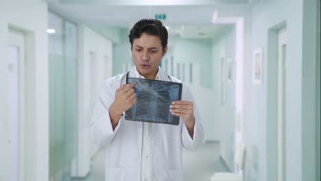 médico indio feliz explicando el informe de rayos x al paciente