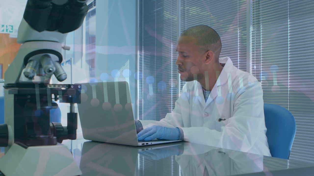 Animation of scientific data over afrcian american male lab worker using laptop