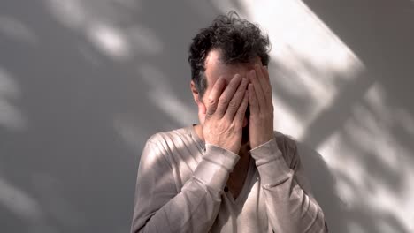 adult male with depression and stress is crying on the wall