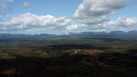 Hermosa-Toma-Aérea-De-Campos-Verdes-Con-Enormes-Mesetas-En-El-Fondo-Del-Parque-Nacional-Chapada-Diamantina-En-Bahia,-Noreste-De-Brasil-En-Un-Cálido-Y-Soleado-Día-De-Verano