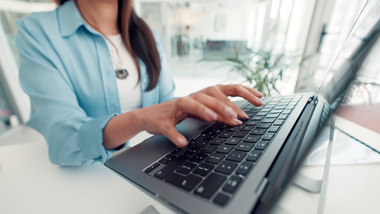 Kvinne som skriver på en laptop på et kontor