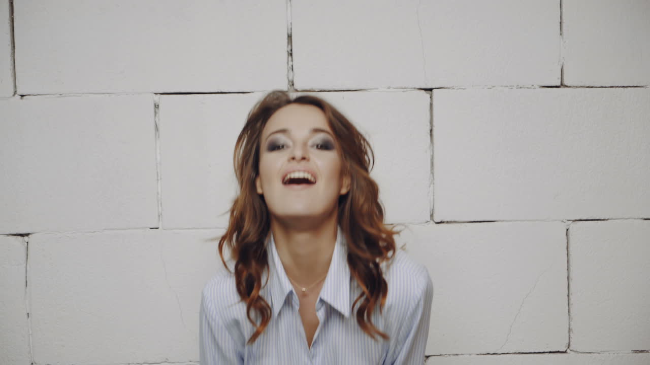 Donna sorridente con camicia a righe azzurra.