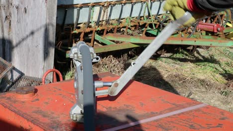 using a hand pump to move fuel to a tractor on a farm in the midwest