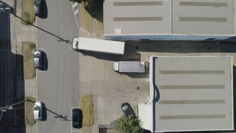 white truck and carry haul leaving depot from aerial perspective on summers day