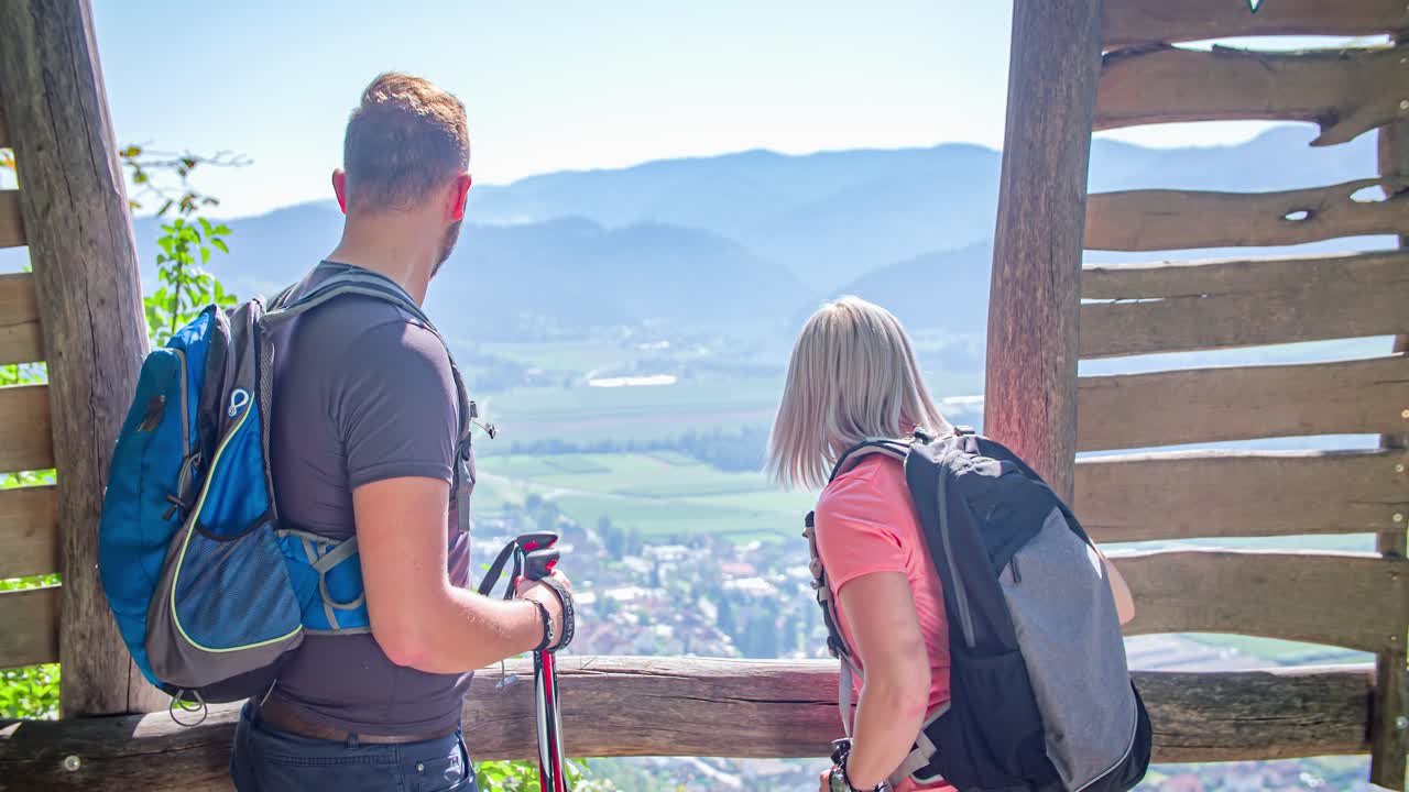 Wide angle dolly in shot of a man and women watching the spectacular Green window, panoramic view point in Radlje on Dravi during the day