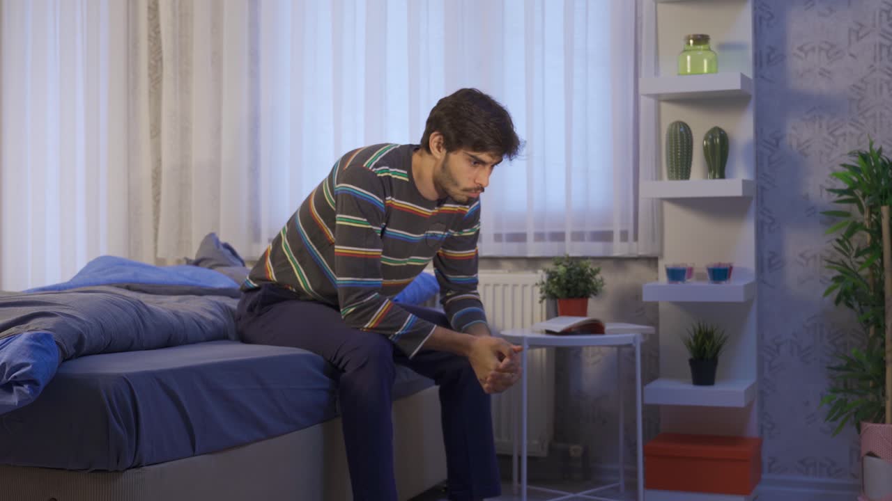 사려 깊은 불행한 젊은이가 그의 방에서 불안감을 느끼고 있습니다.