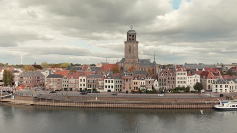 aerial drone shot backing up from the dutch medieval city of deventer revealing the river ijssel that passes by on a cloudy day