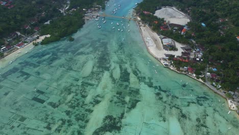 imágenes aéreas de drones en 4k: scooters cruzando el icónico y pintoresco puente amarillo que conecta las islas nusa lembongan y nusa ceningan en bali