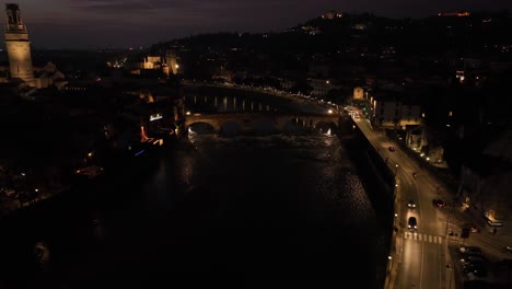 aerial drone shot toward pietra's bridge in verona at night