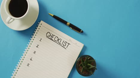 video of notebook with checklist and copy space, coffee and pencil on blue surface