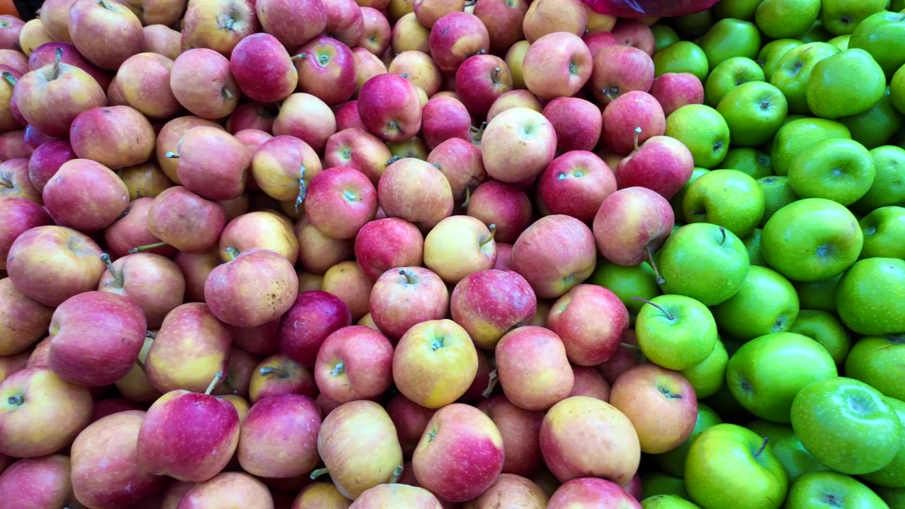 Verse rode en groene appels uitgestald op een markt.