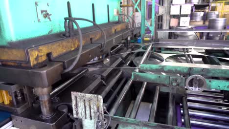 a machine stamps out drum can lids from large sheets of steel