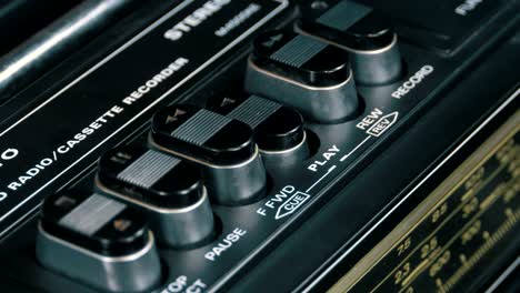 pushing play button on a vintage tape recorder
