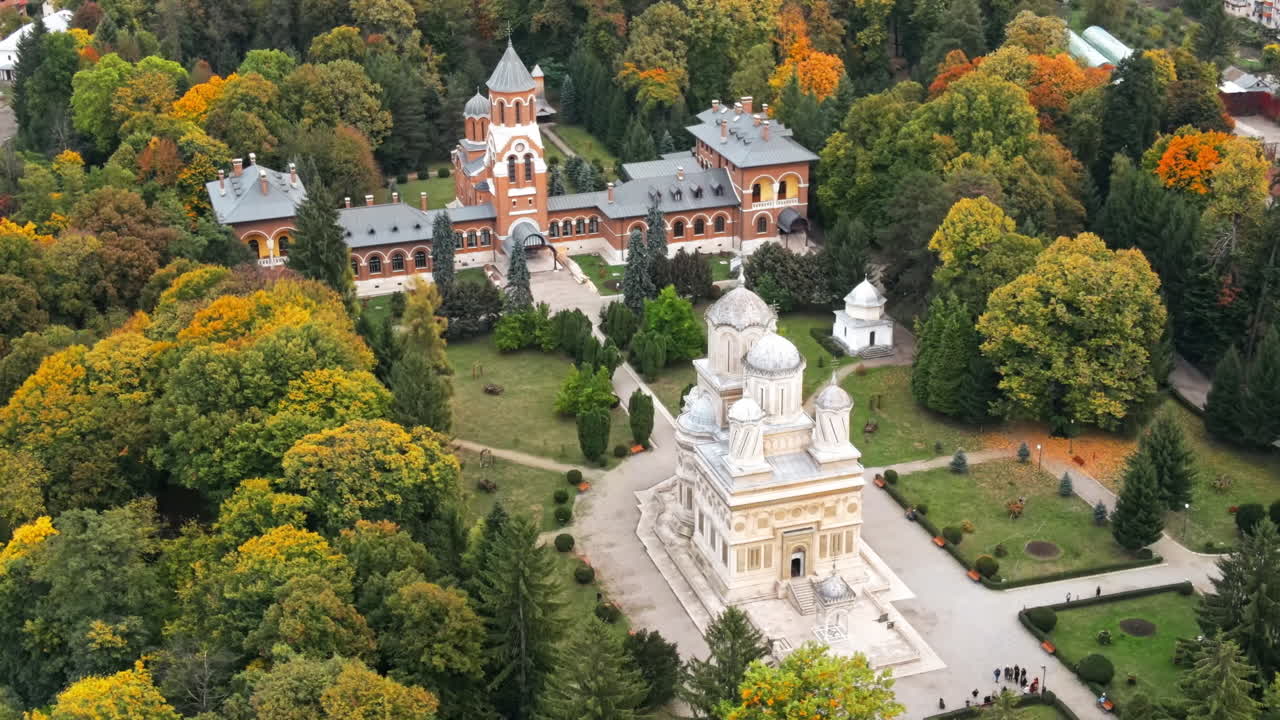 Aerial drone view of The Cathedral of Curtea de Arges, Romania. Episcopal Church, square with greenery and people