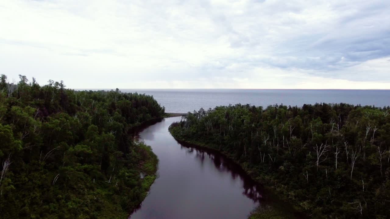하늘 반사와 함께 큰 호수로 흐르는 강 공중 촬영