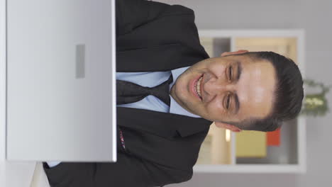 Vertical-video-of-Home-office-worker-man-working-on-laptop.