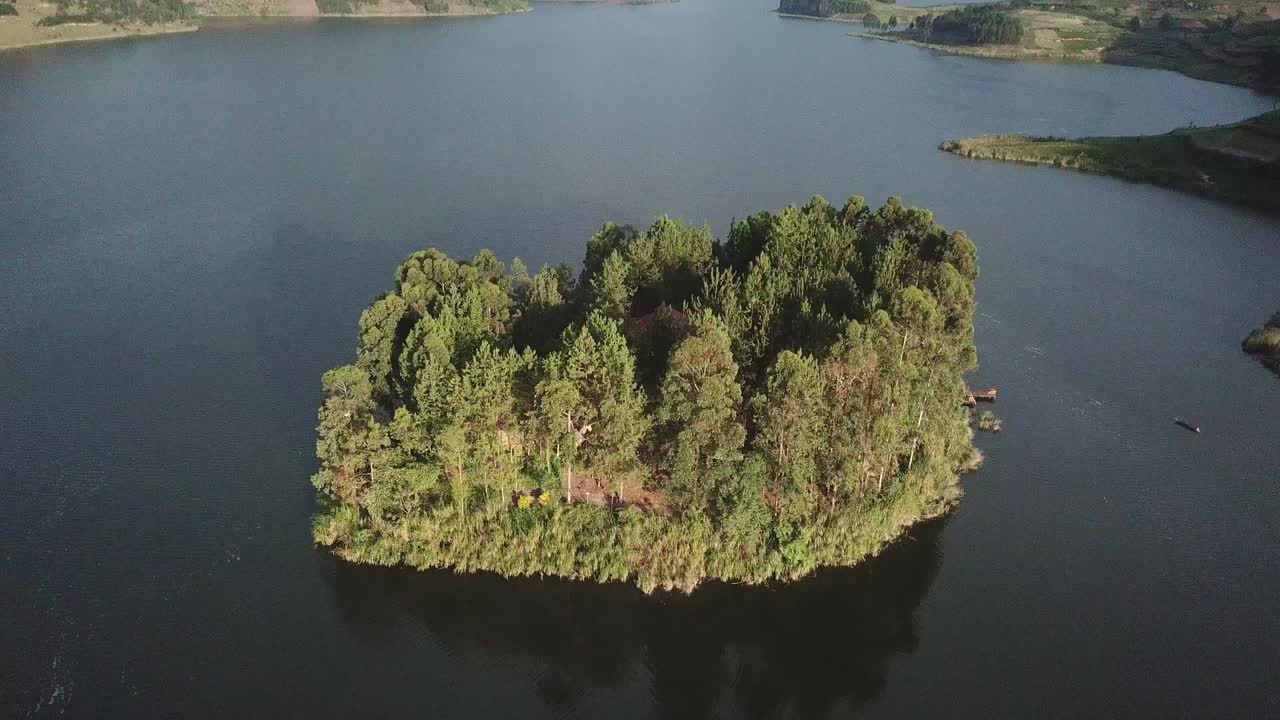 우간다의 부니요니 호수 (lake bunyonyi) 에 있는 은 나무가 있는 섬 위로 내려갑니다.