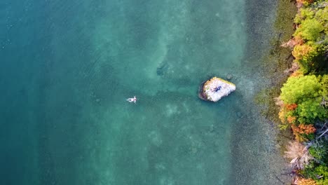 Frau-Schwimmt-Zum-Felsen-Im-Lake-Huron,-Michigan