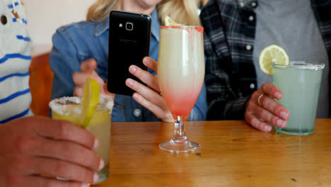 amigos usando el teléfono móvil mientras beben 4k
