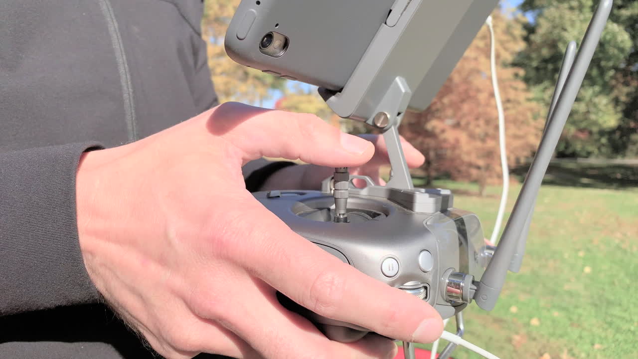 드론 조종사가 드론을 조종하기 위해 리모콘을 조작하고 있습니다.