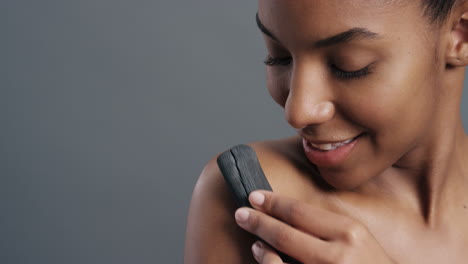 close up portrait gorgeous african american woman gently touching skin with charcoal caressing soft natural complexion enjoying sensual exfoliation beauty concept