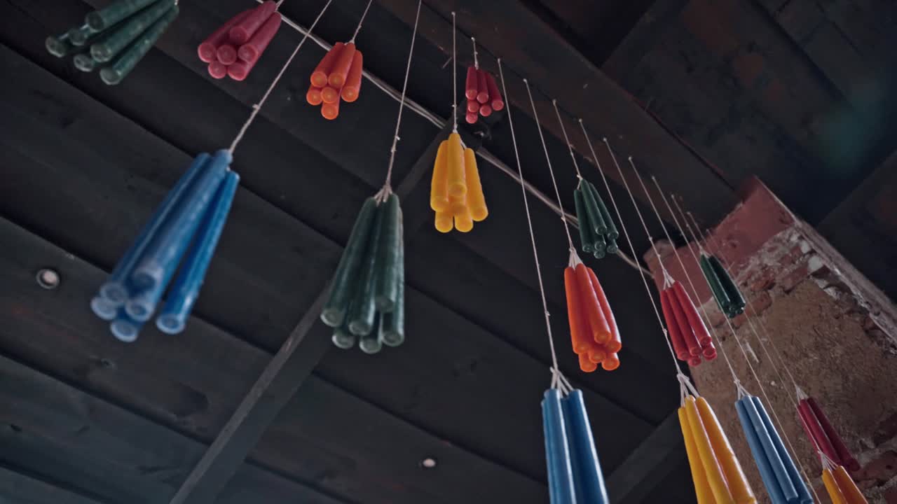 velas de colores colgando de una cuerda en guatemala