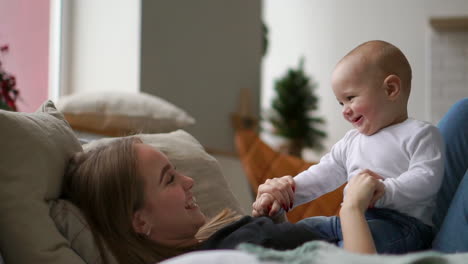 the best moments from life, a loving happy young mother hugs a nursing son, on a snow-white blanket, on a white background. concept of love, family, and happiness concept: children, kids, baby, babies