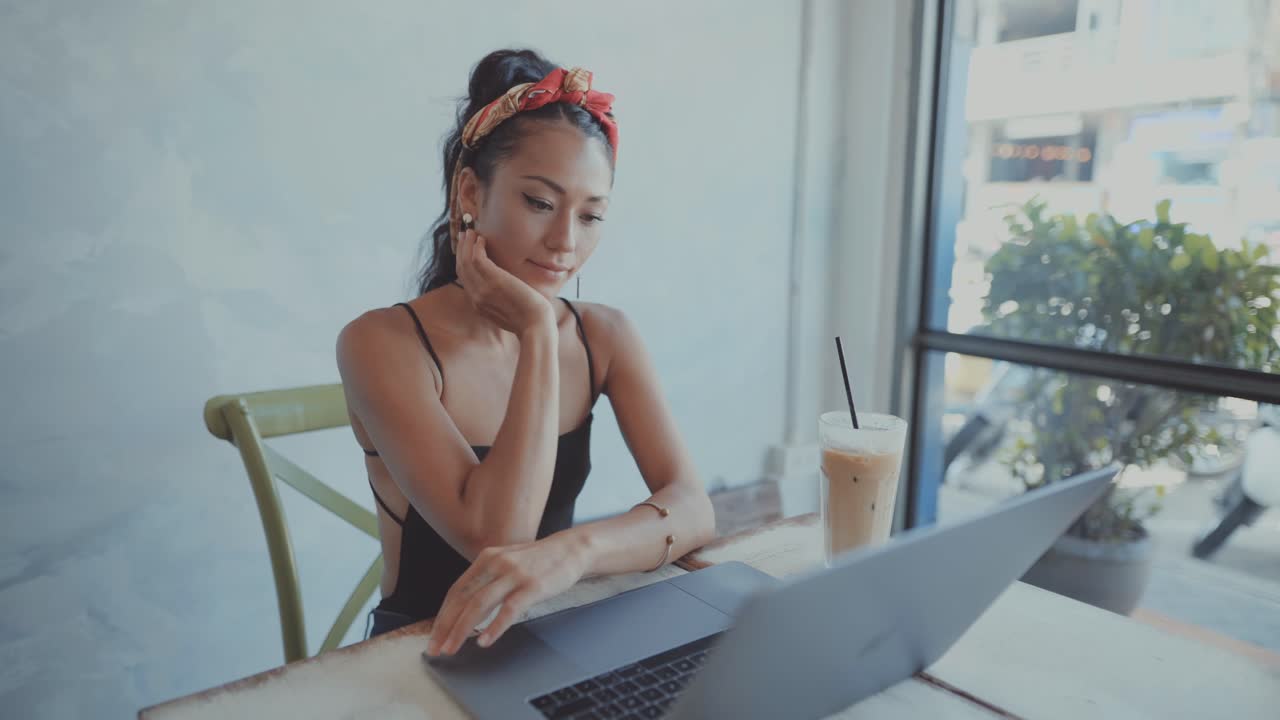 Woman working on laptop in a cafe