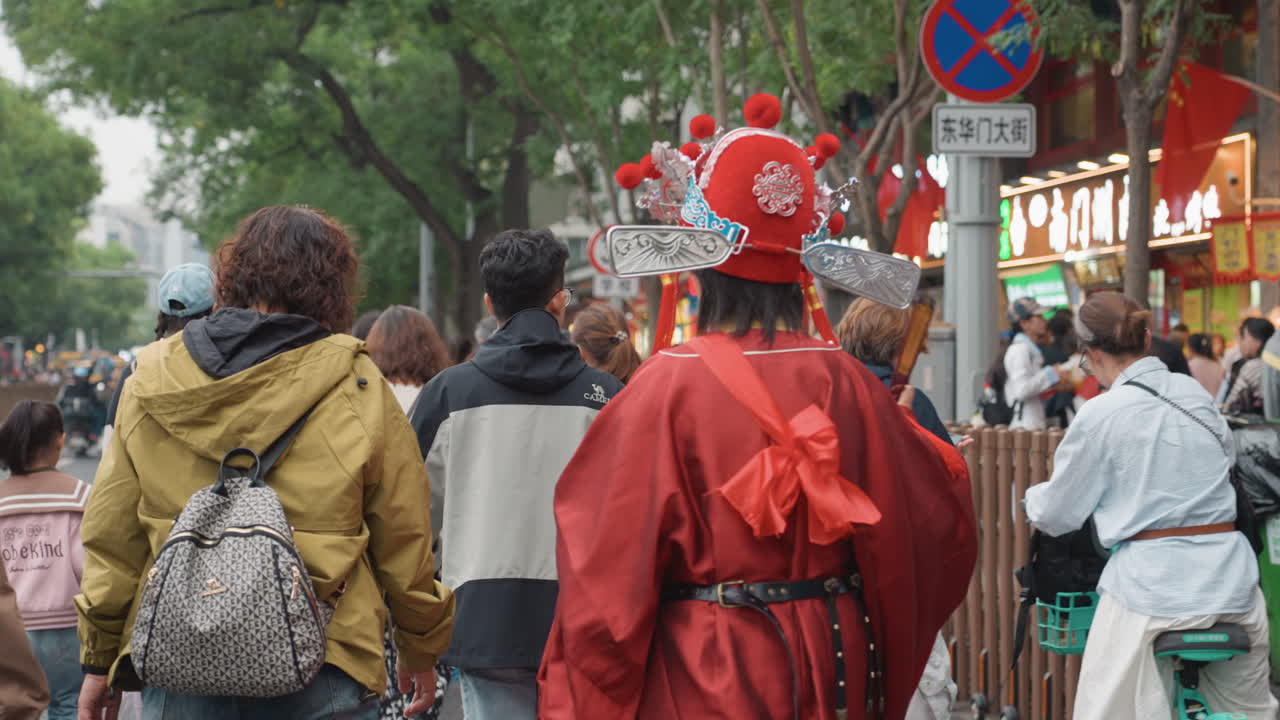 Sposa asiatica in abito rosso cammina attraverso un mercato di strada affollato, copricapo d'argento decorato, compagno con zaino, curiosi osservatori, lanterne festive, luce diurna nuvolosa, lenta processione tra gli acquirenti