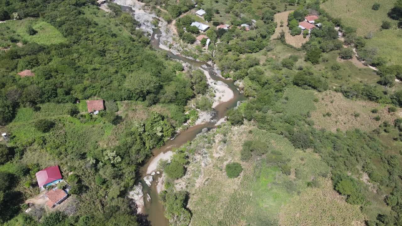 vista aérea de un área cerca de un río con áreas rocosas y casas pequeñas