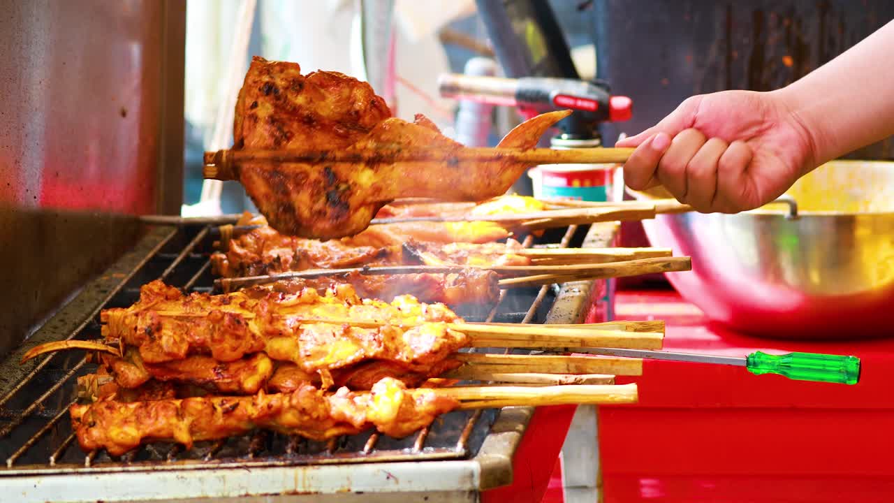 비는 고기 를 바쁜 시장 의 상점 에서 요리 하는 것