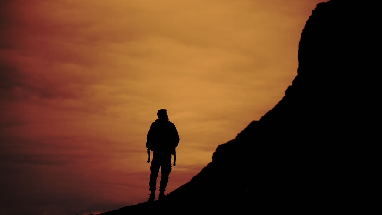 Silhouette of a man on a mountain at sunset