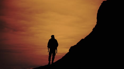 silhouette of a man on a mountain at sunset