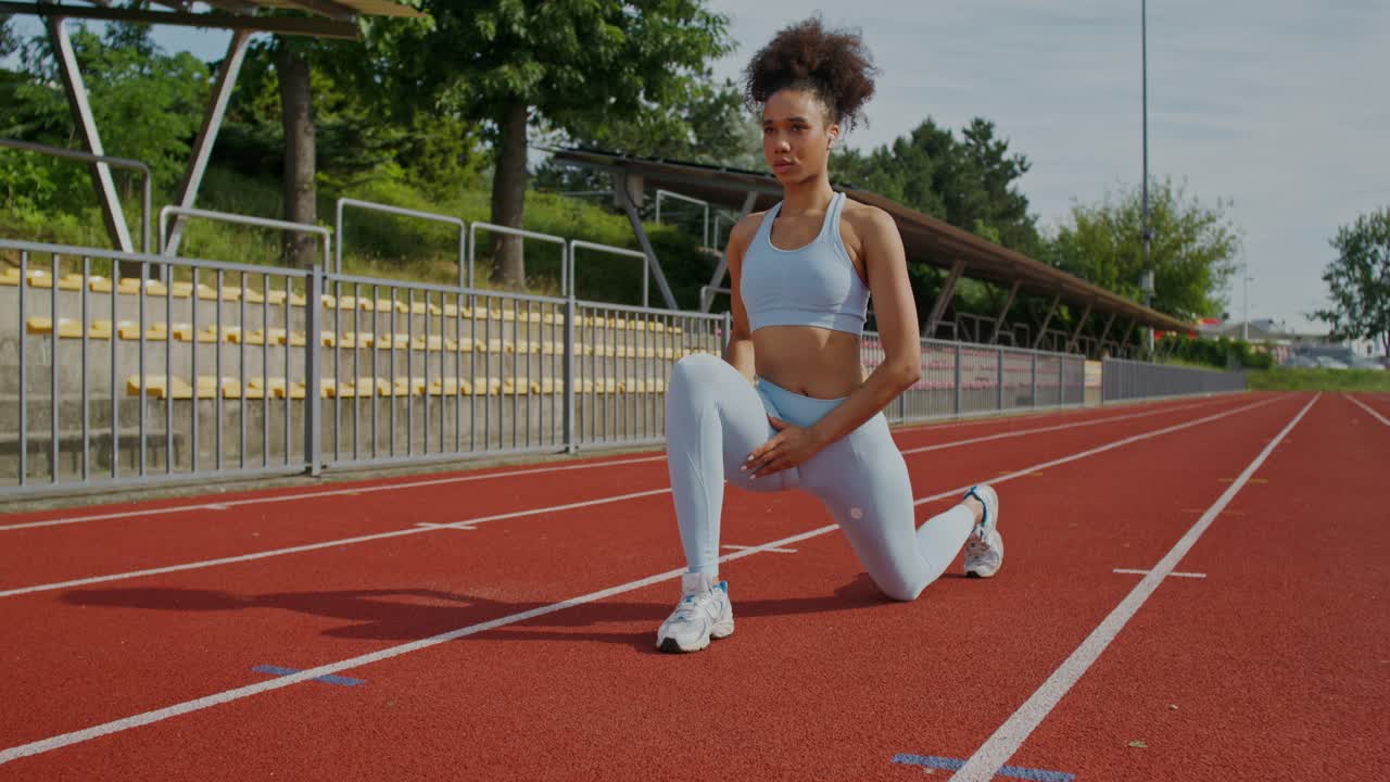 mulher esticando em uma pista de corrida
