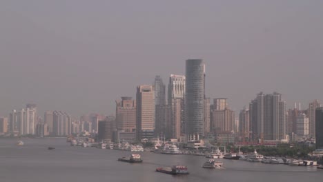 Skyline-of-Tokyo-bay-with-large-skyscrapers-in-the-background-and-ships-sailing-on-the-water