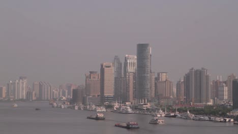 skyline of tokyo bay with large skyscrapers in the background and ships sailing on the water