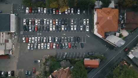 Aerial-closing-footage-of-a-parking-lot-in-a-mountain-town-4K