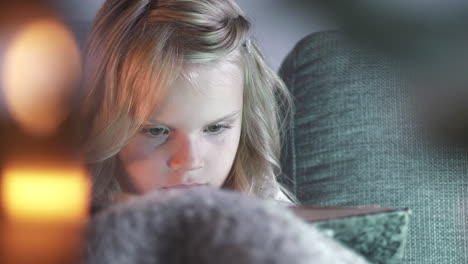 young blonde girl captivated reading book